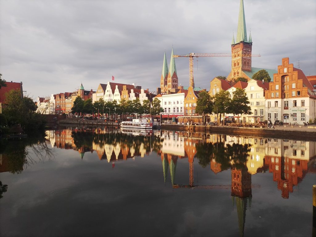 Panorama im schönsten Sonnenlicht von der Lübecker Altstadt. Vom Westufer der Obertrave fotografiert. Kostenlos mit Quellenangabe nutzbar.